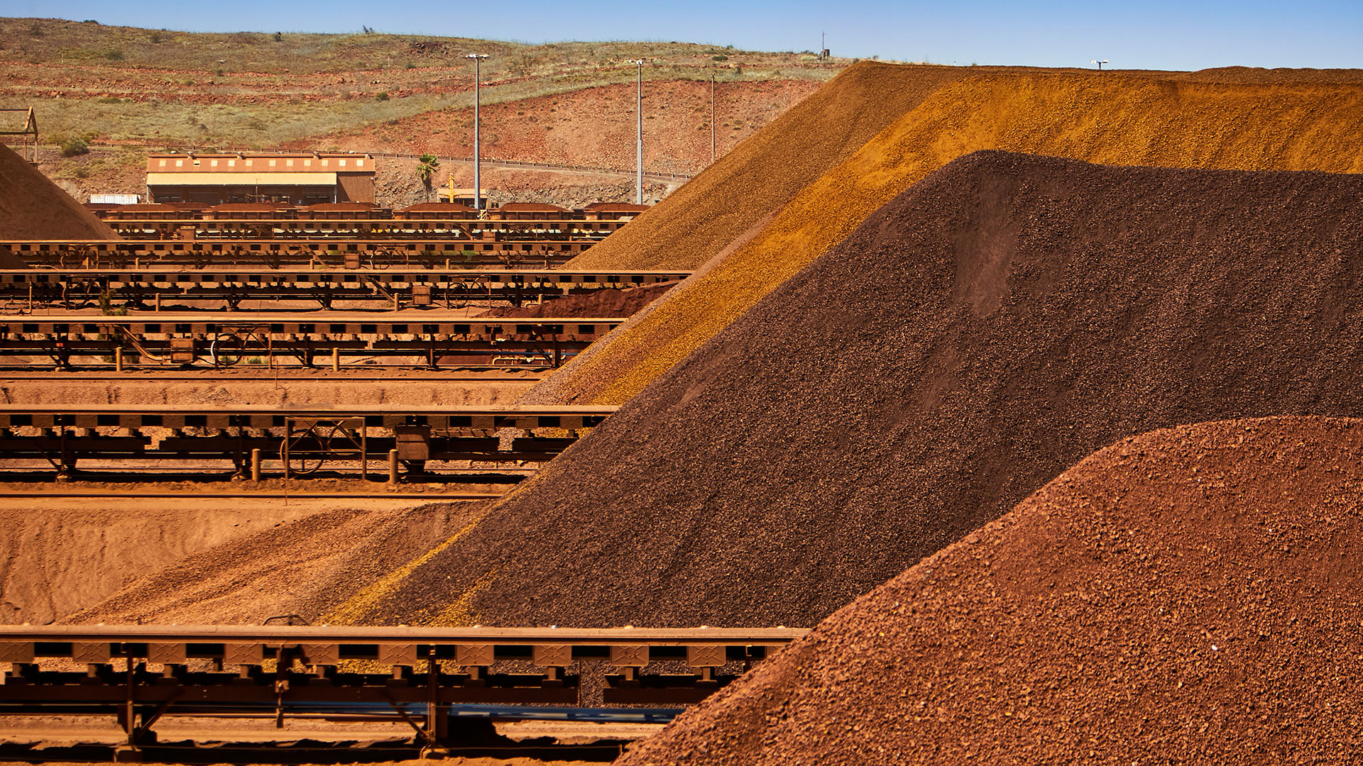 Pilbara mining site with iron ore stockpiles and conveyors for ACHM project assessment context