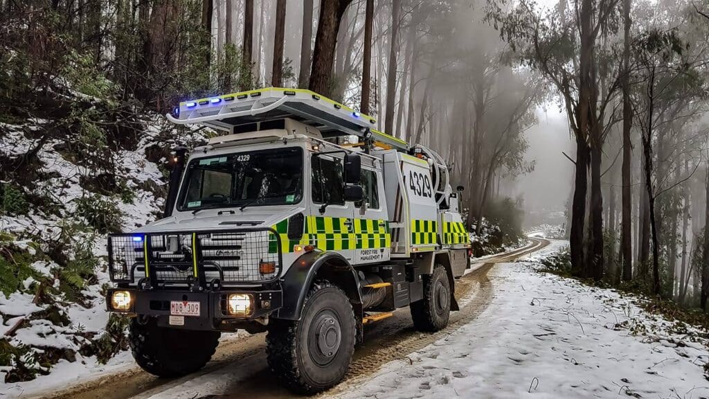 Emergency management vehicle on snowy forest road for ACHM project assessment context