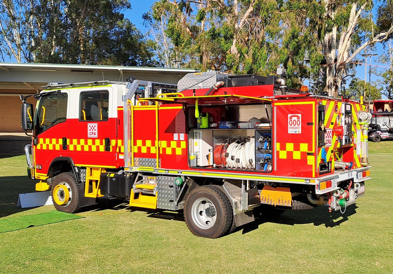 Red CFA fire truck with open side compartments showing hoses and emergency equipment